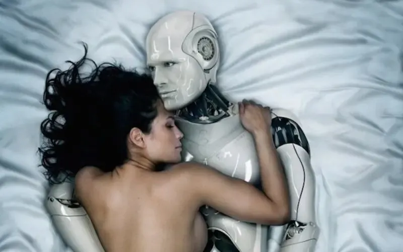 A woman embraces a humanoid robot while lying on a bed, creating an intimate scene.